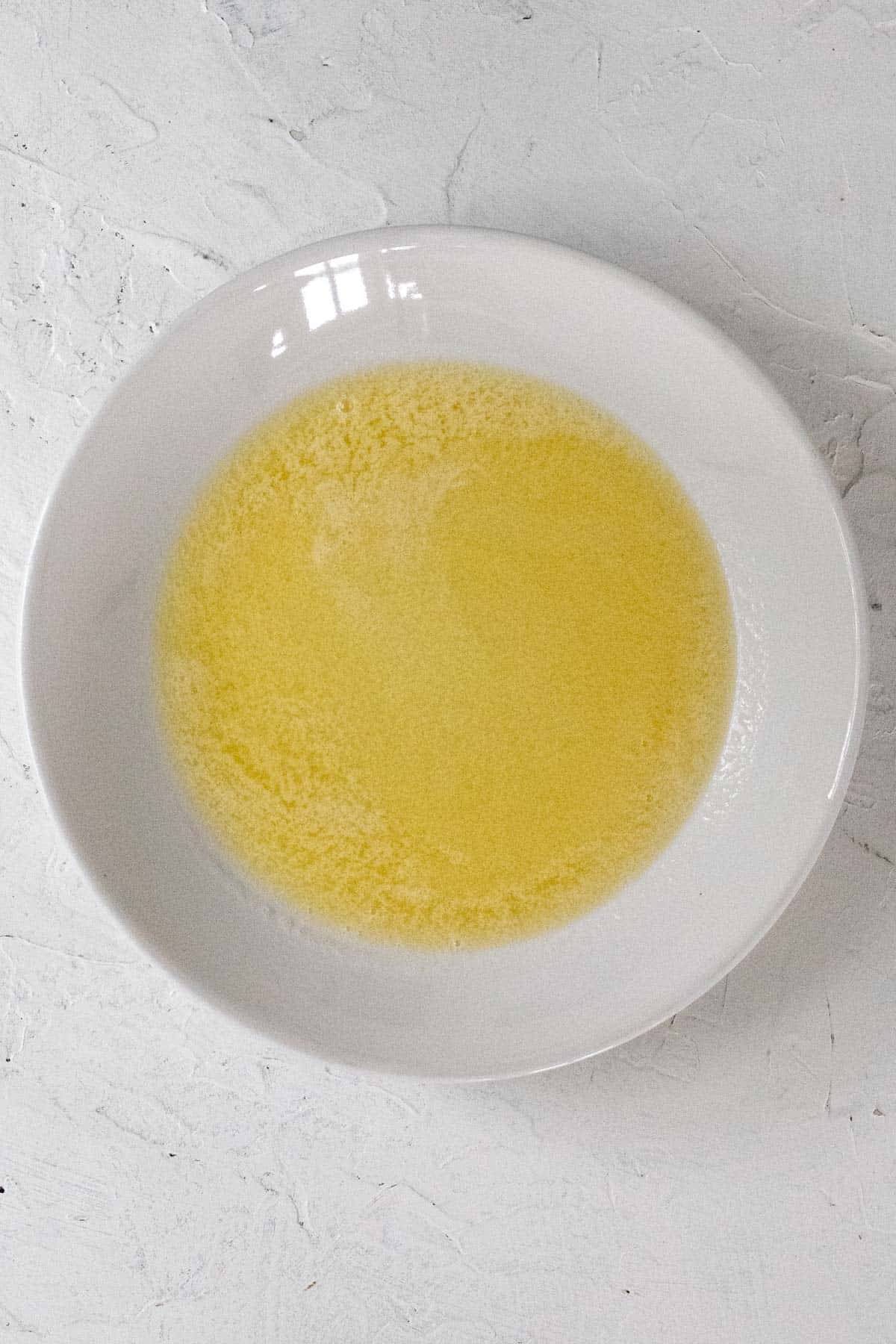 Melted butter in a white bowl.