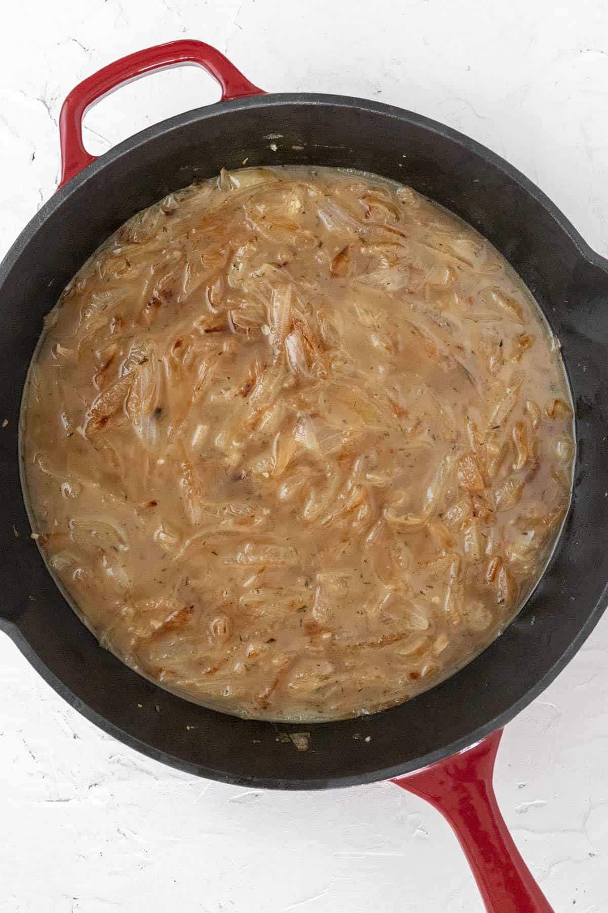 Broth added to the cast iron skillet with the caramelized onions.