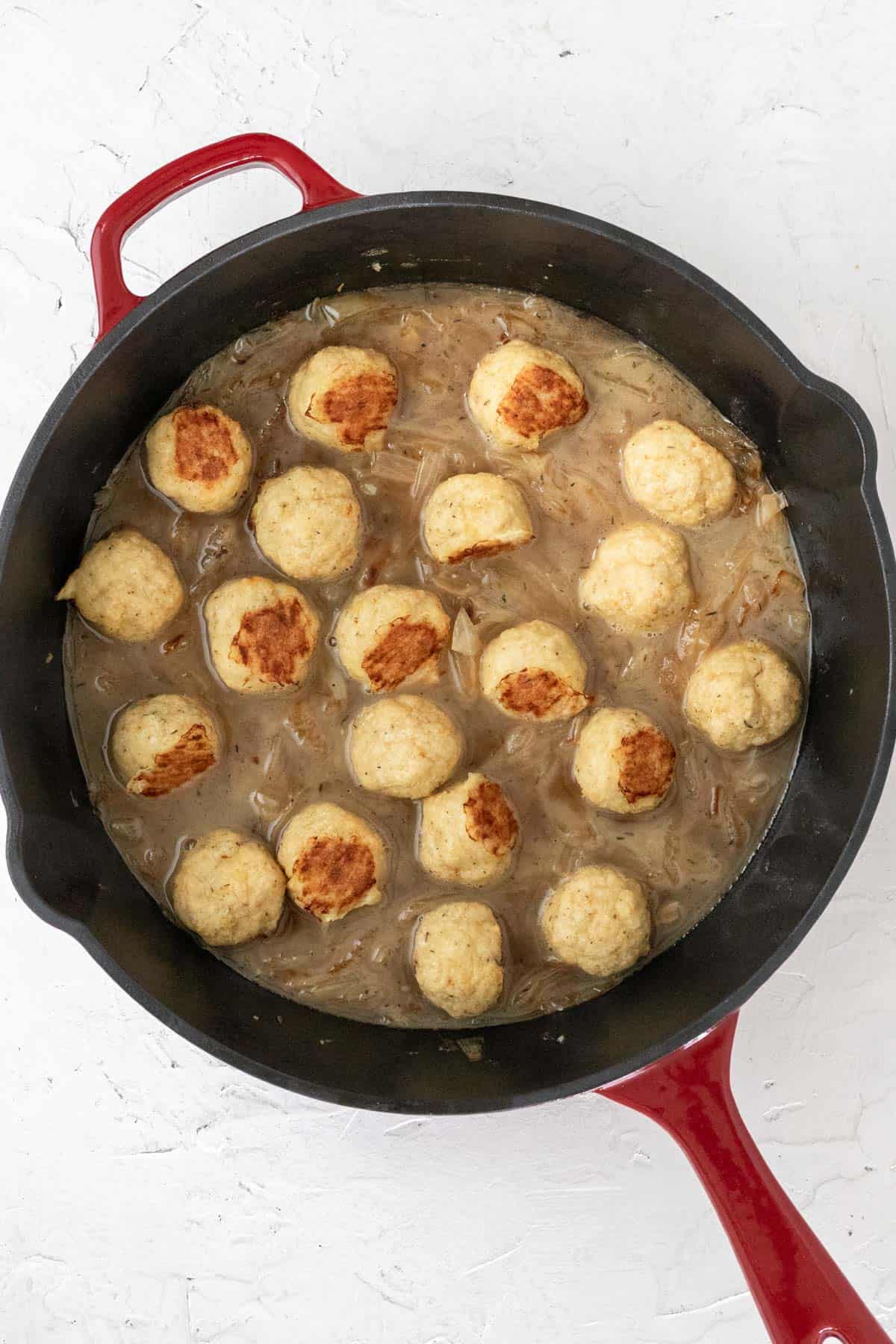 Baked chicken meatballs added to the skillet with the caramelized onions and chicken broth.