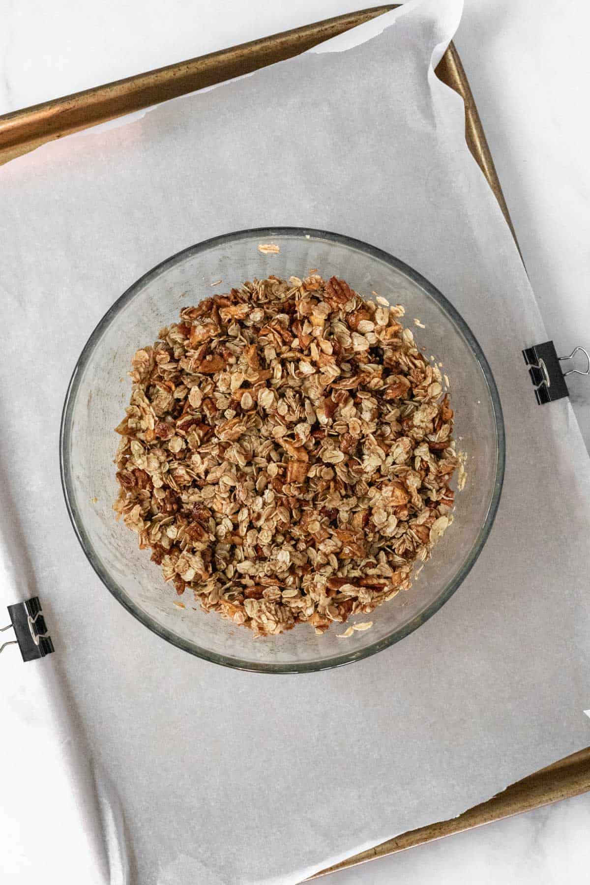 Granola ingredients mixed together in a glass bowl.