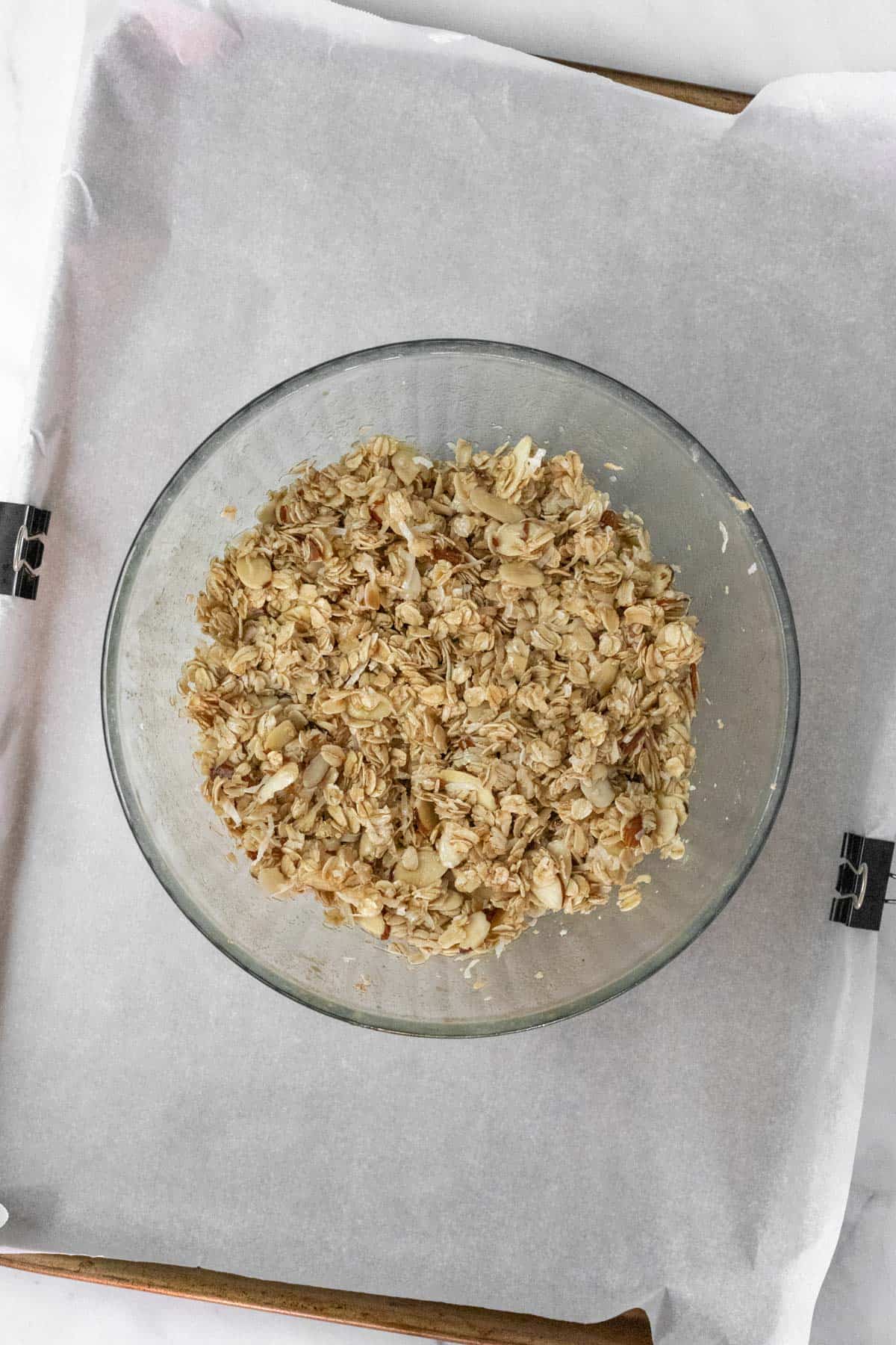 Ingredients for homemade granola mixed together in a glass bowl.