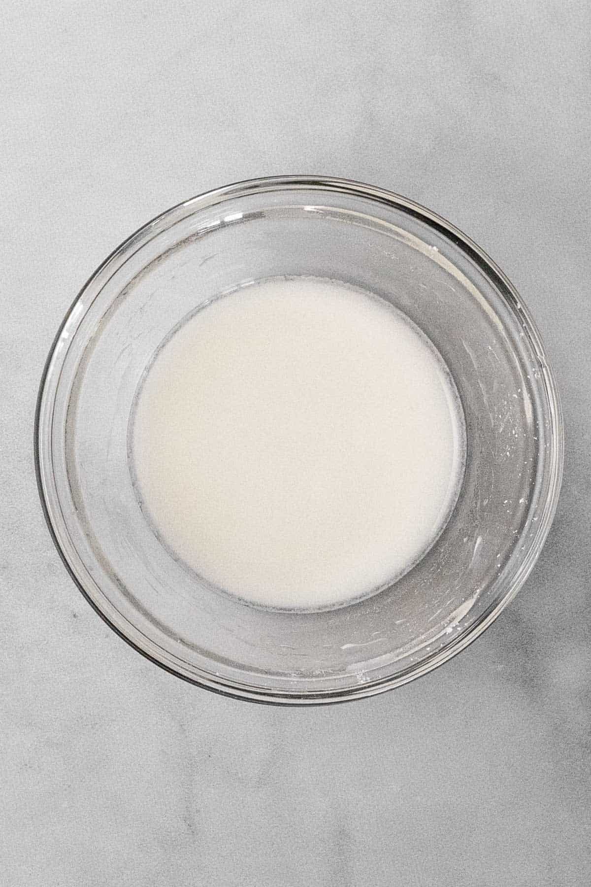 A corn starch slurry in a glass mixing bowl.