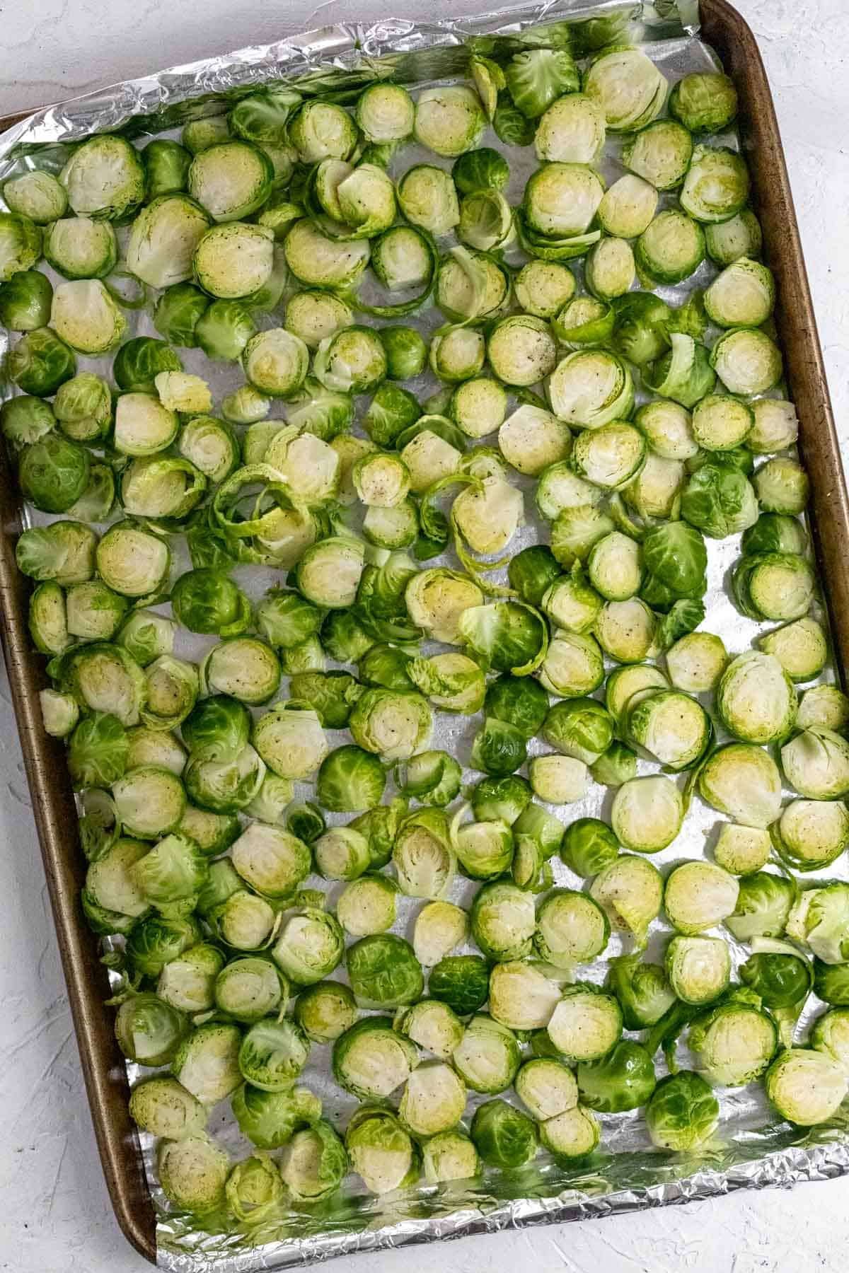 Sliced brussels sprouts on a sheet pan before going in the oven.