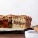 A slice of apple cider and date coffee cake with a swirl of cinnamon sugar in the middle.