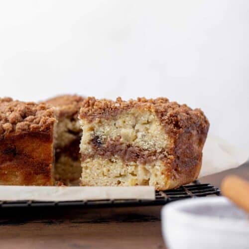 A slice of apple cider and date coffee cake with a swirl of cinnamon sugar in the middle.