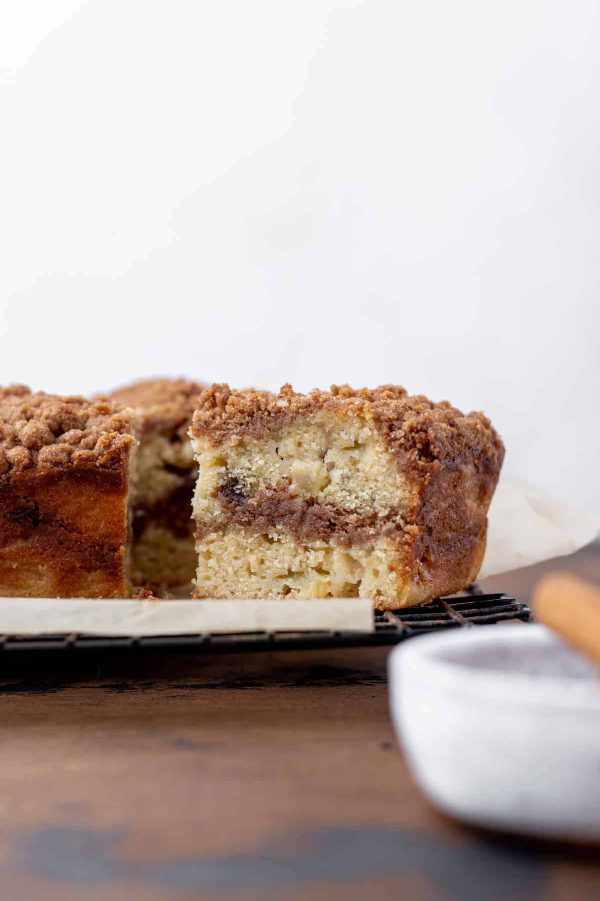 A slice of apple cider and date coffee cake with a swirl of cinnamon sugar in the middle.