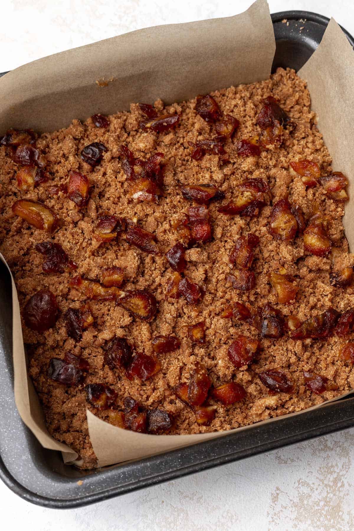 Chopped dates on top of the raw apple cider coffee cake.