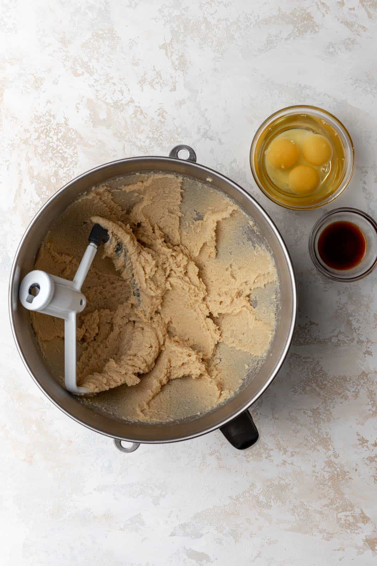 A mixing bowl with creamed butter and sugars.