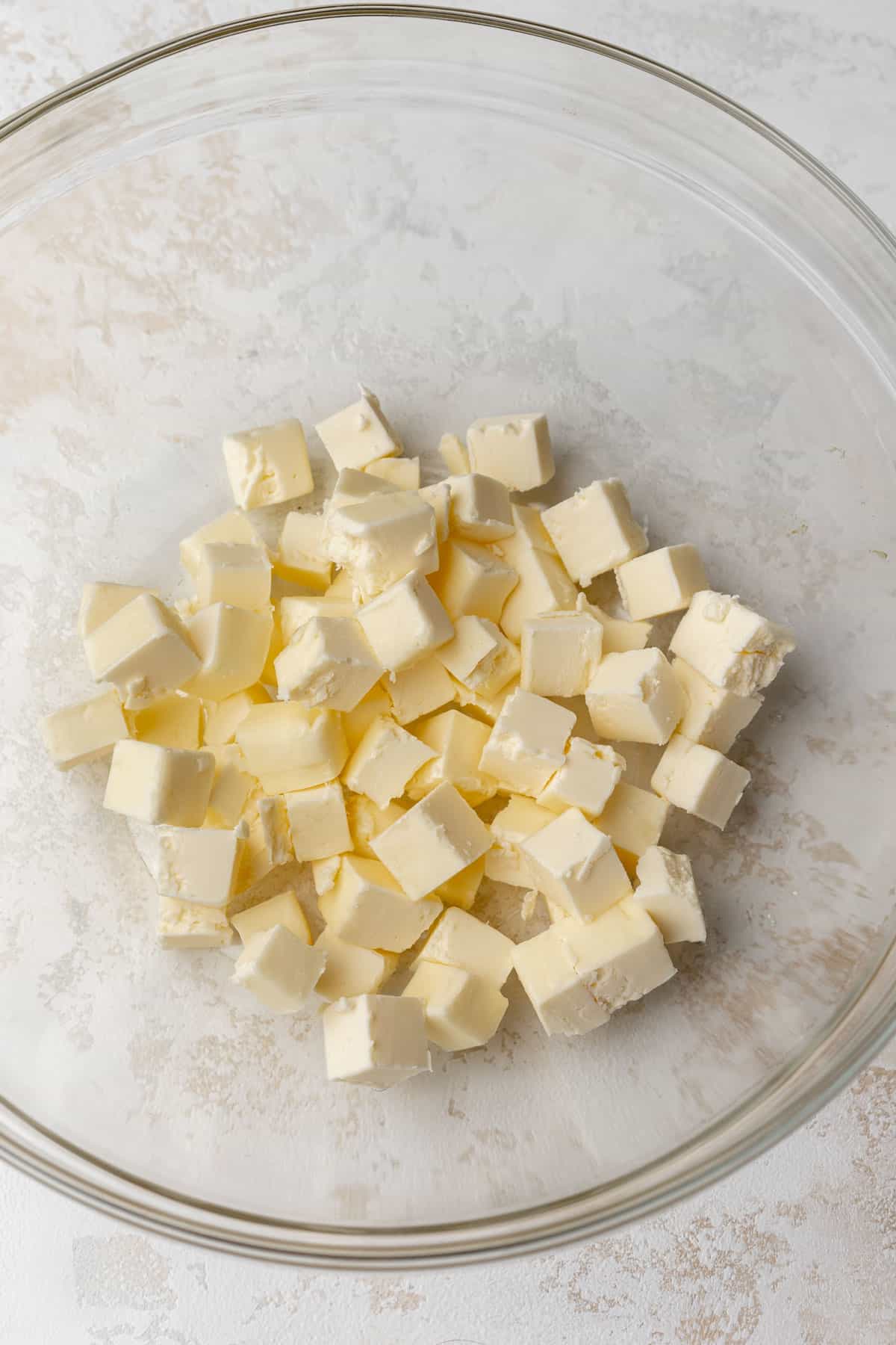 Cubed butter in a glass mixing bowl.