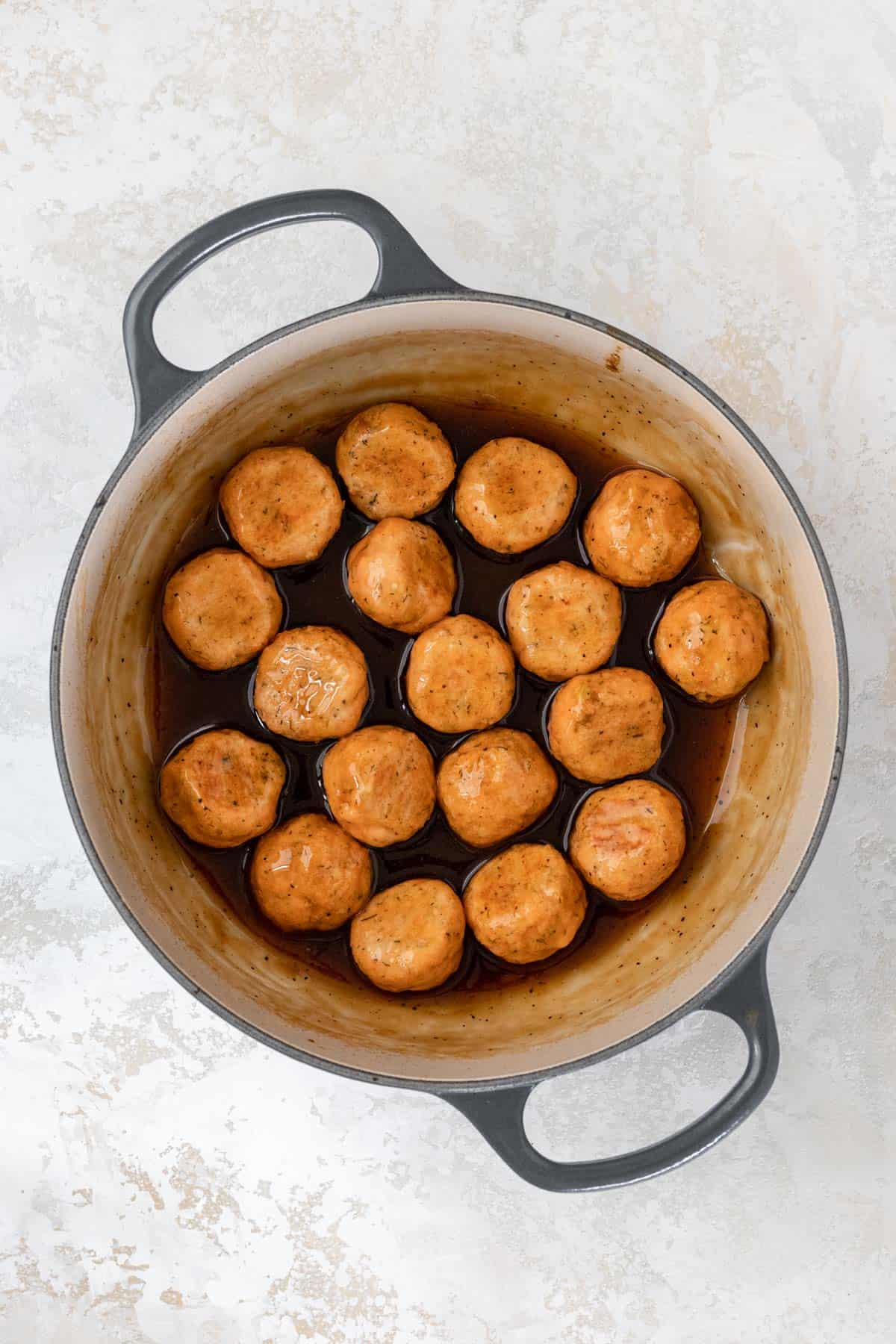 Bourbon glazed salmon meatballs in a large pot.