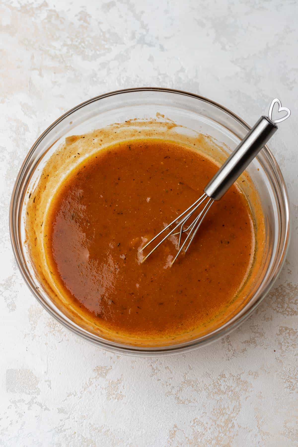 Pumpkin vinaigrette whisked together in a glass mixing bowl.