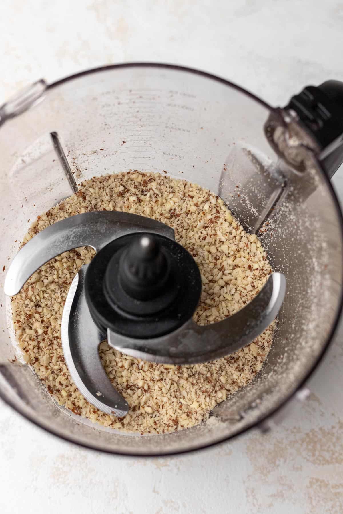 Pulverized almonds in the base of a food processor.