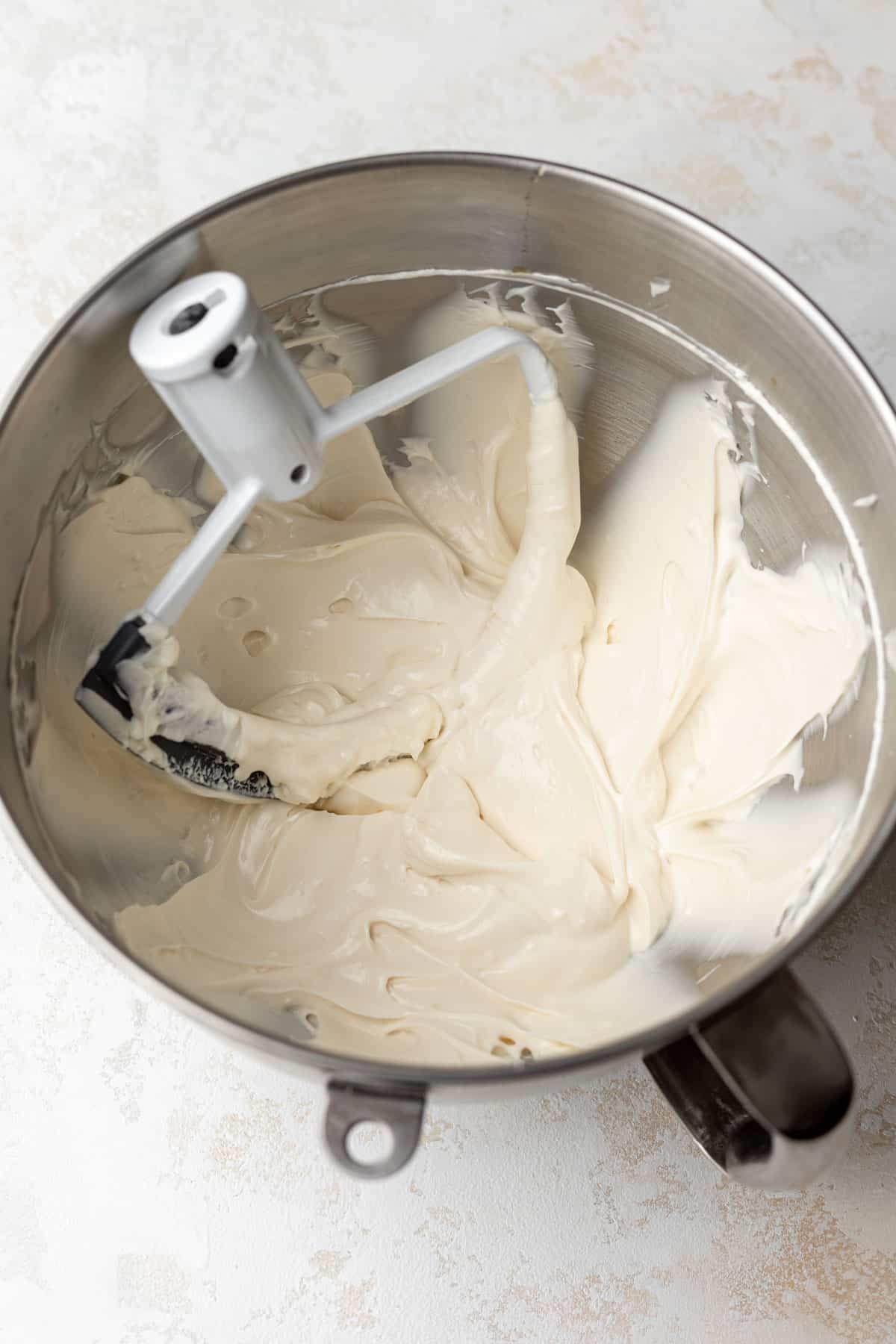Healthy cheesecake batter beaten in the bowl of a stand mixer.