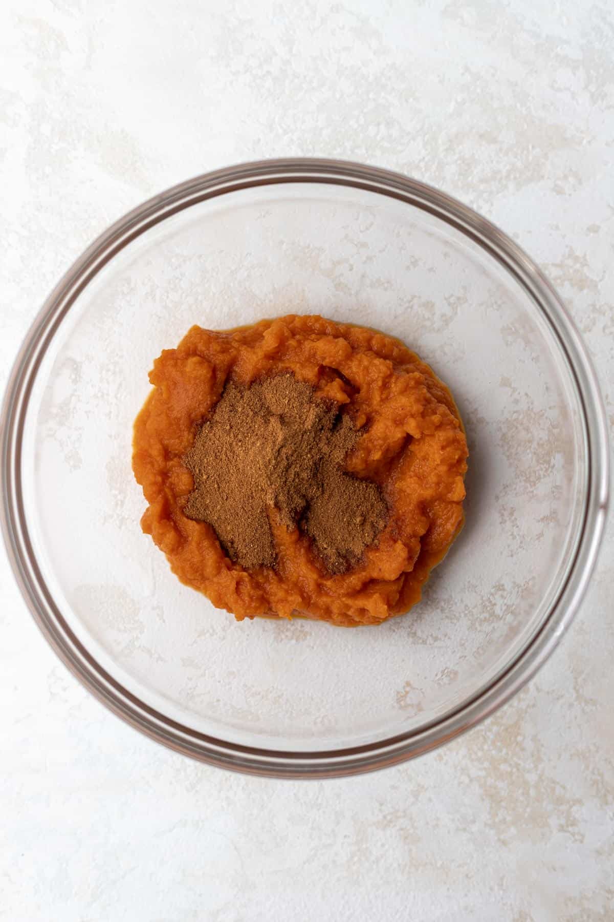 Pumpkin puree mixed with spices in a glass bowl.