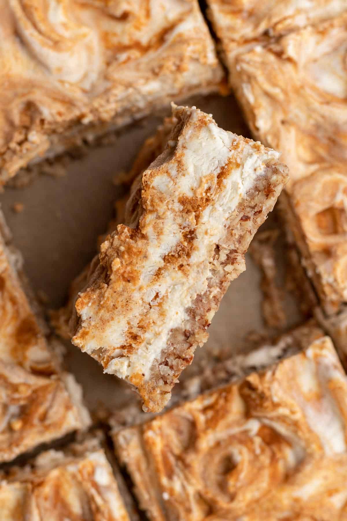 An inside view of a cheesecake bar so you can see the pumpkin swirl in the middle.