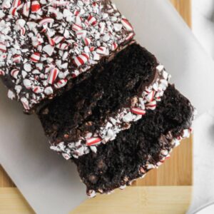 Chocolate peppermint zucchini bread sliced on a wooden cutting board.