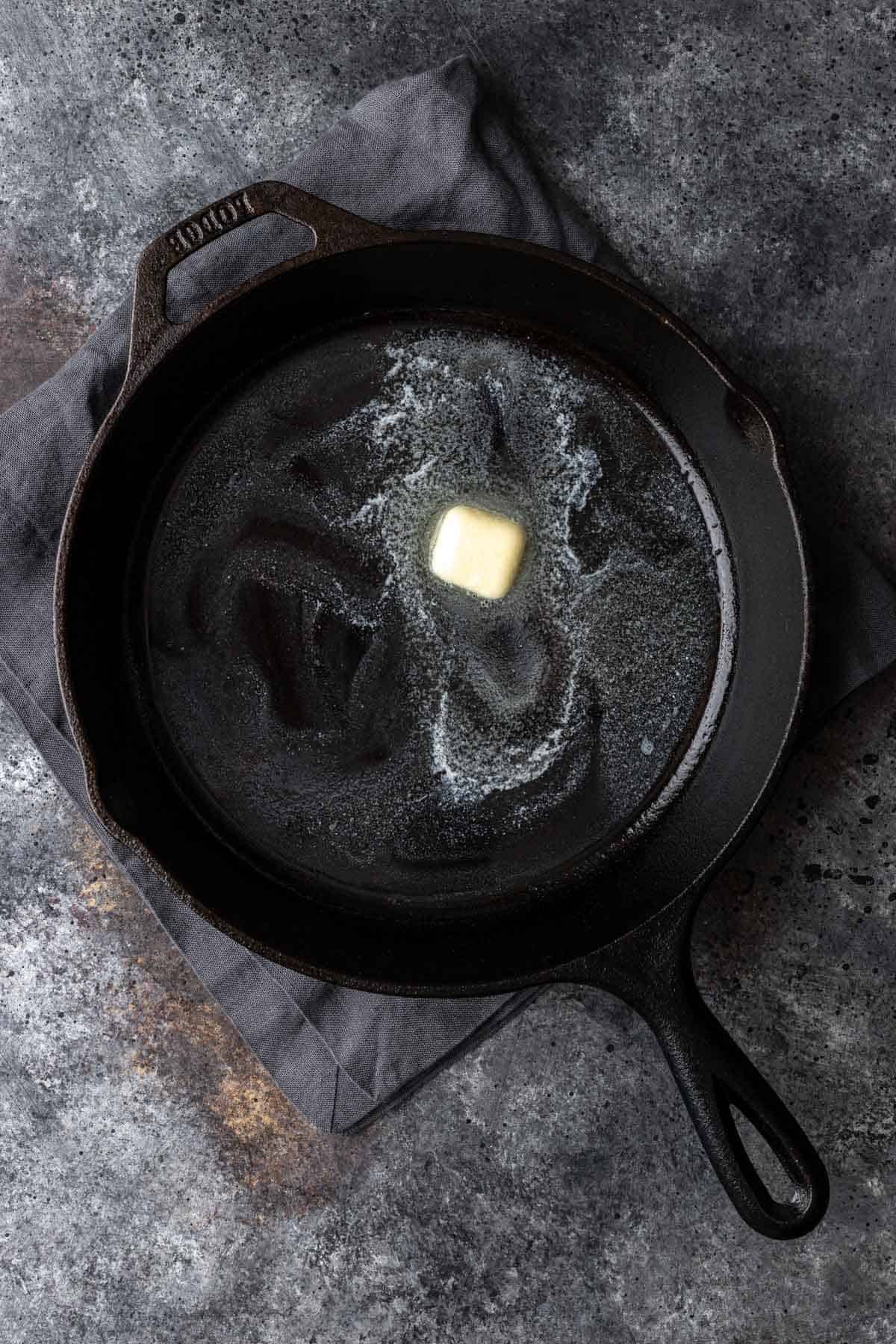 Butter melted in the bottom of a cast iron skillet.