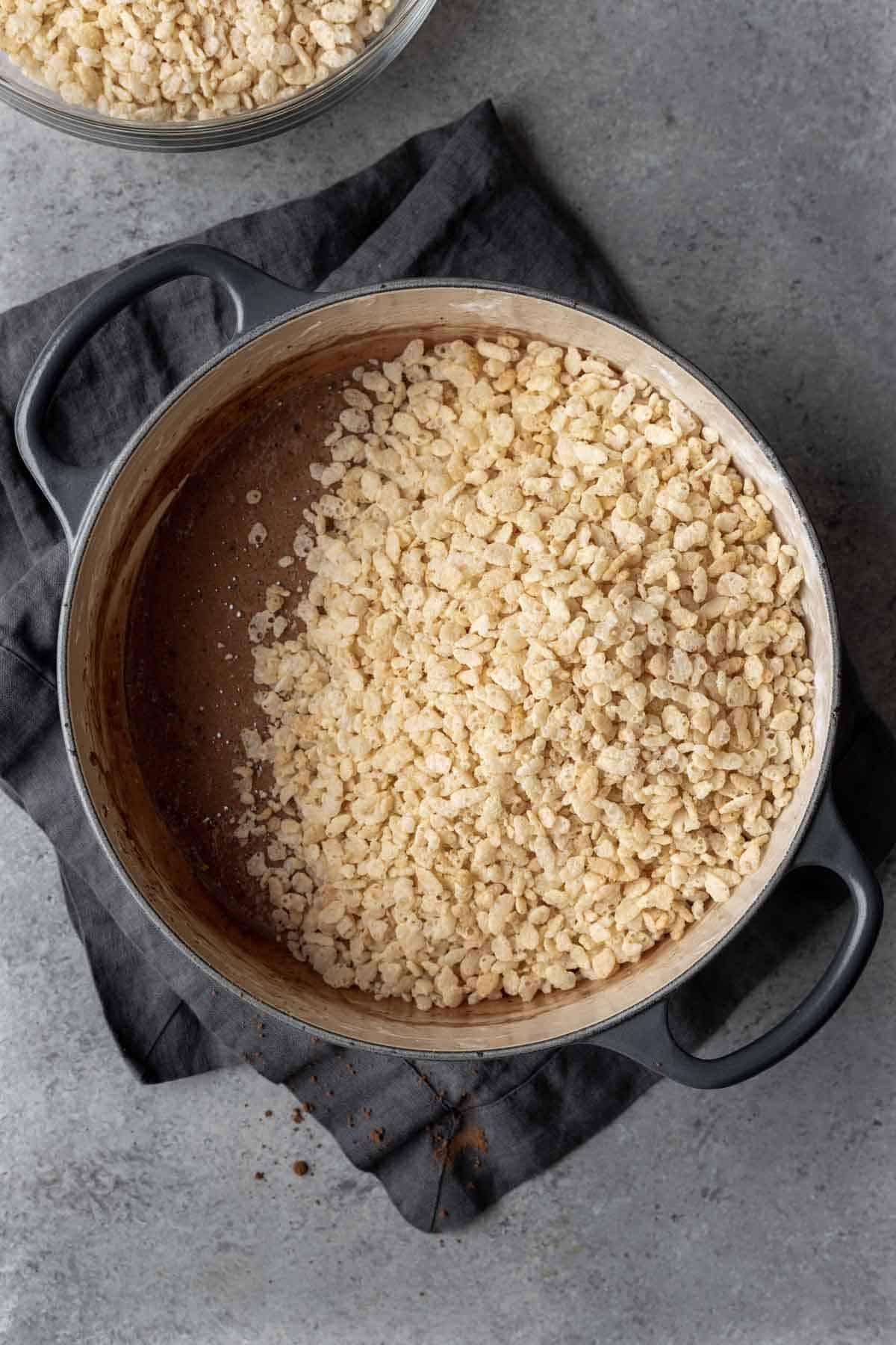 Crispy rice cereal on top of melted marshmallows mixed with cocoa powder.