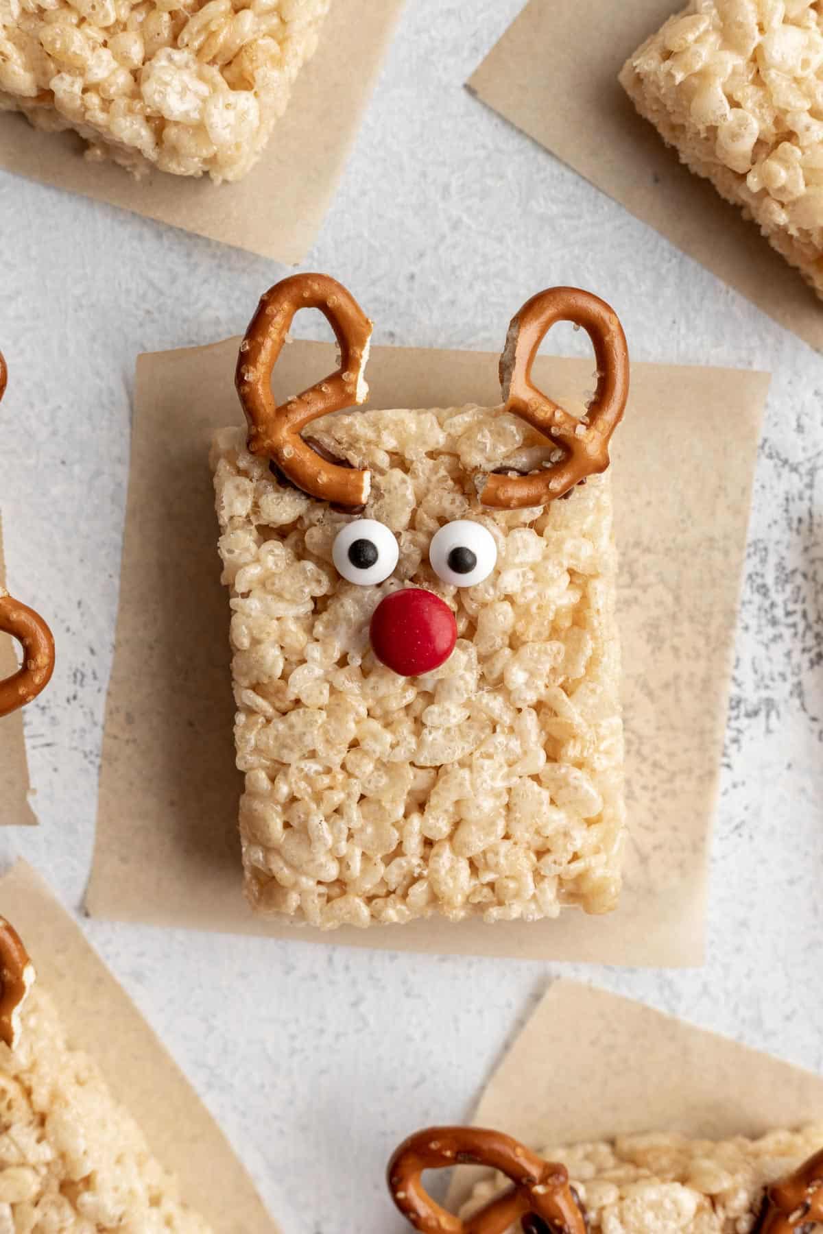 A fully assembled reindeer rice krispie treat on parchment paper.