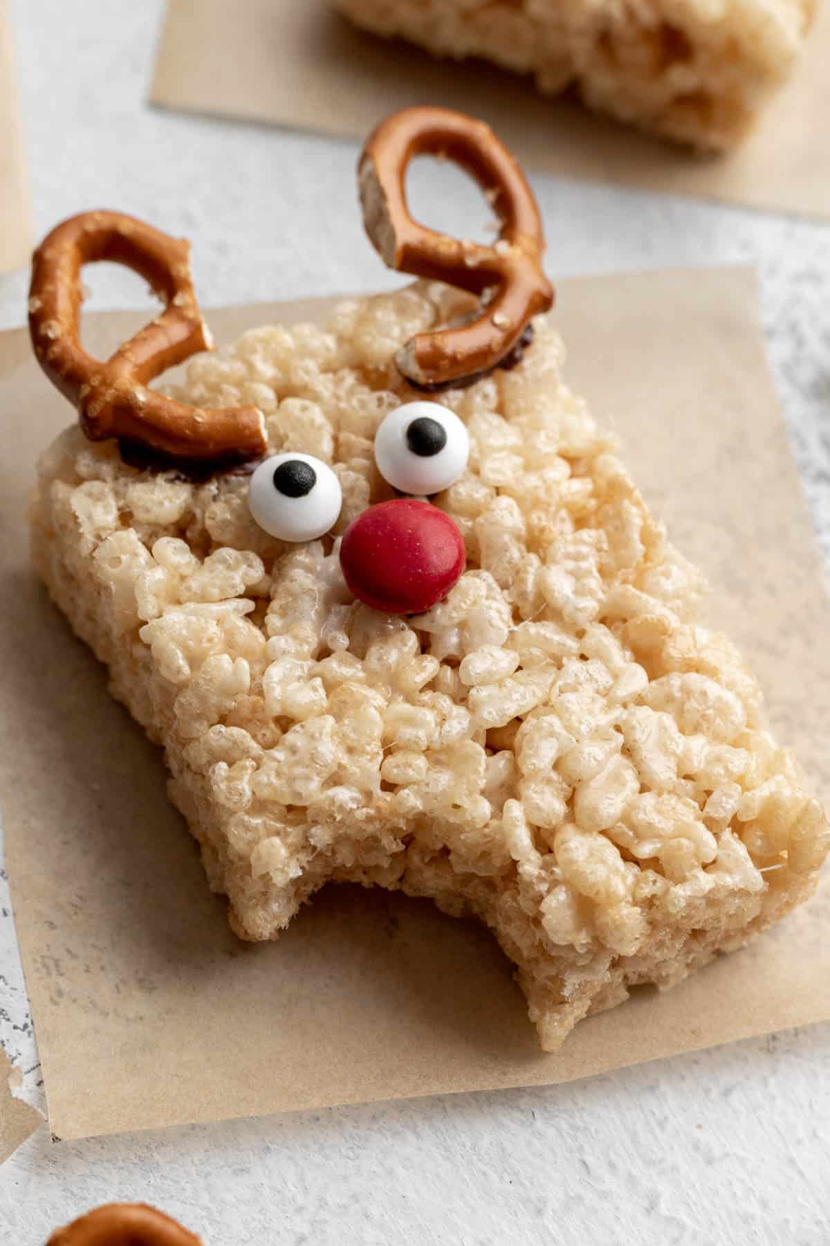 A reindeer rice krispie treat with a bite taken out of it.
