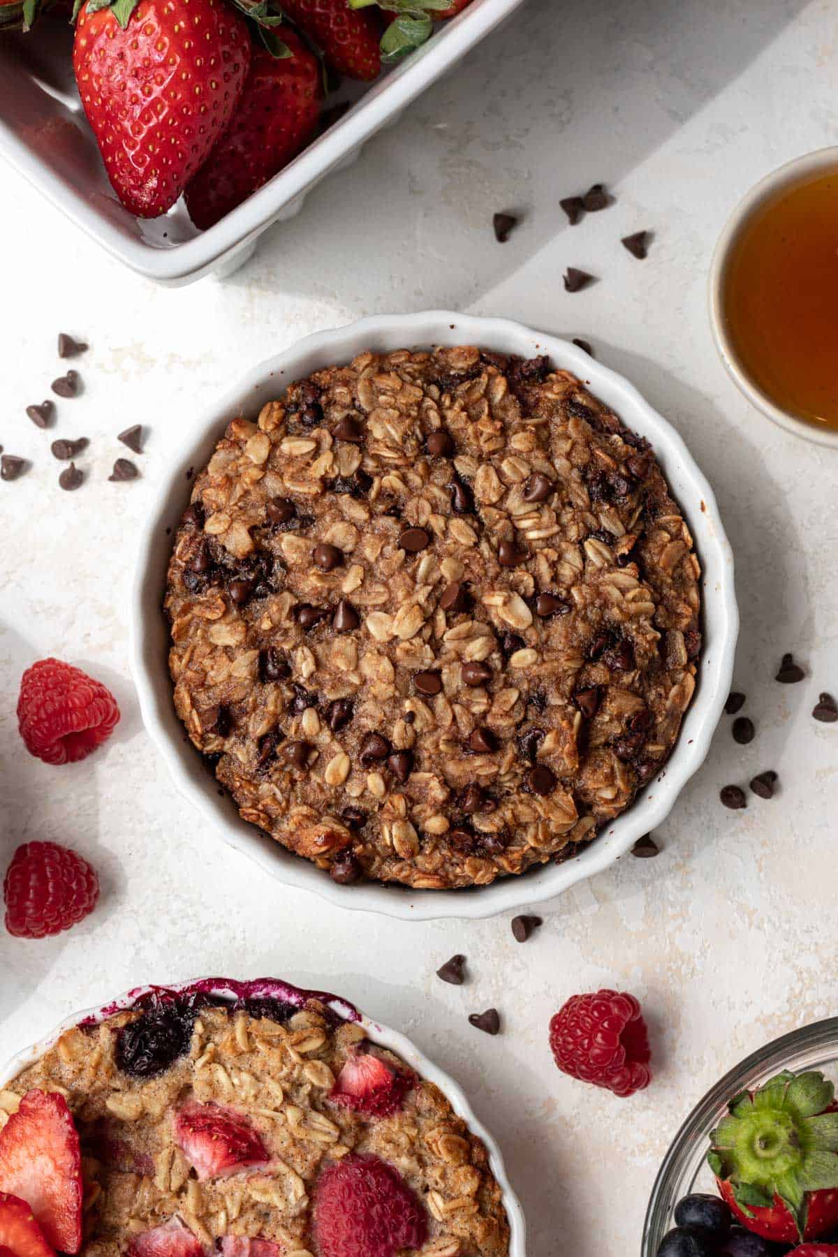 Chocolate chip baked oats for one with raspberries and chocolate chips around it.