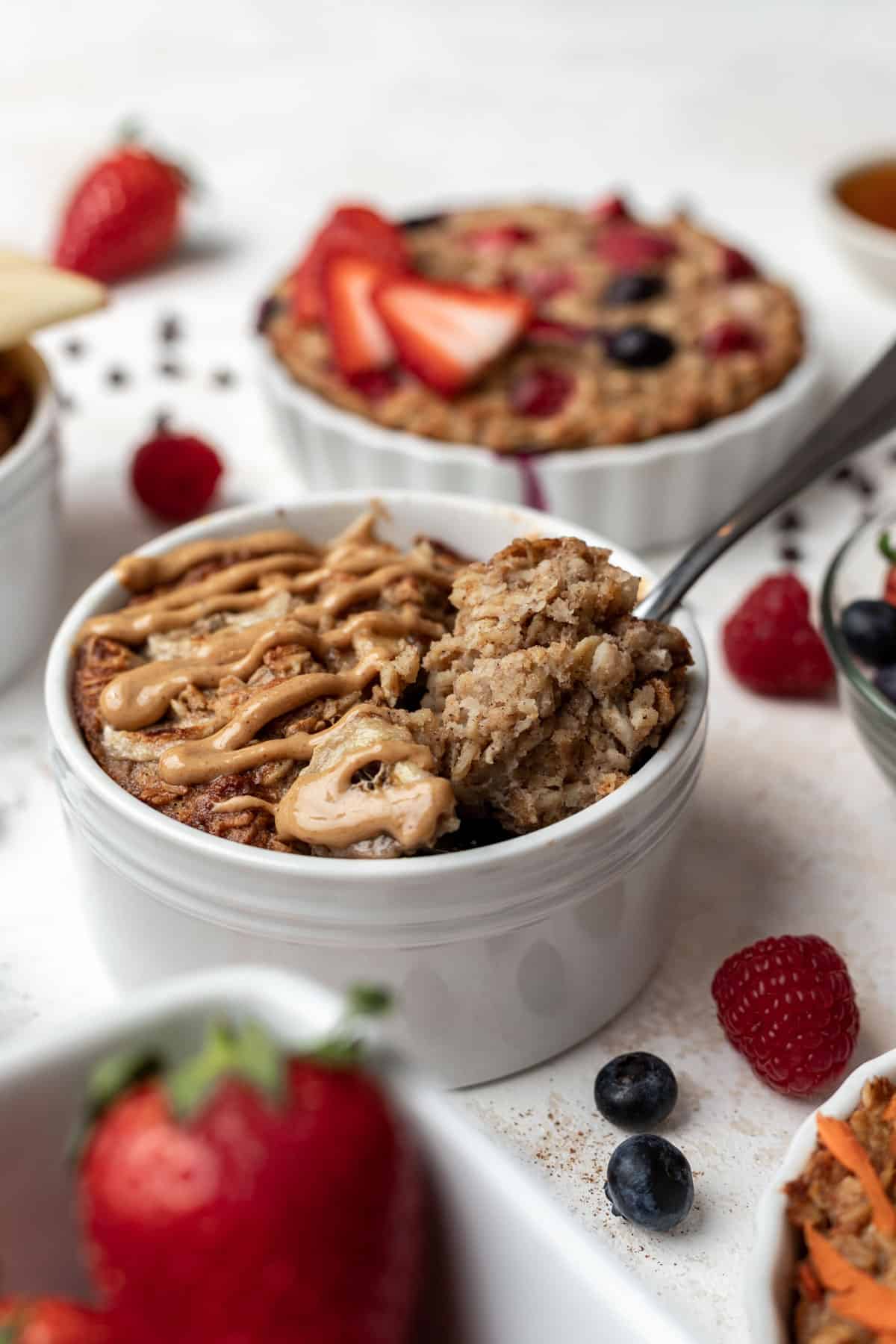 Peanut butter banana baked oats in a white ramekin with a spoon.