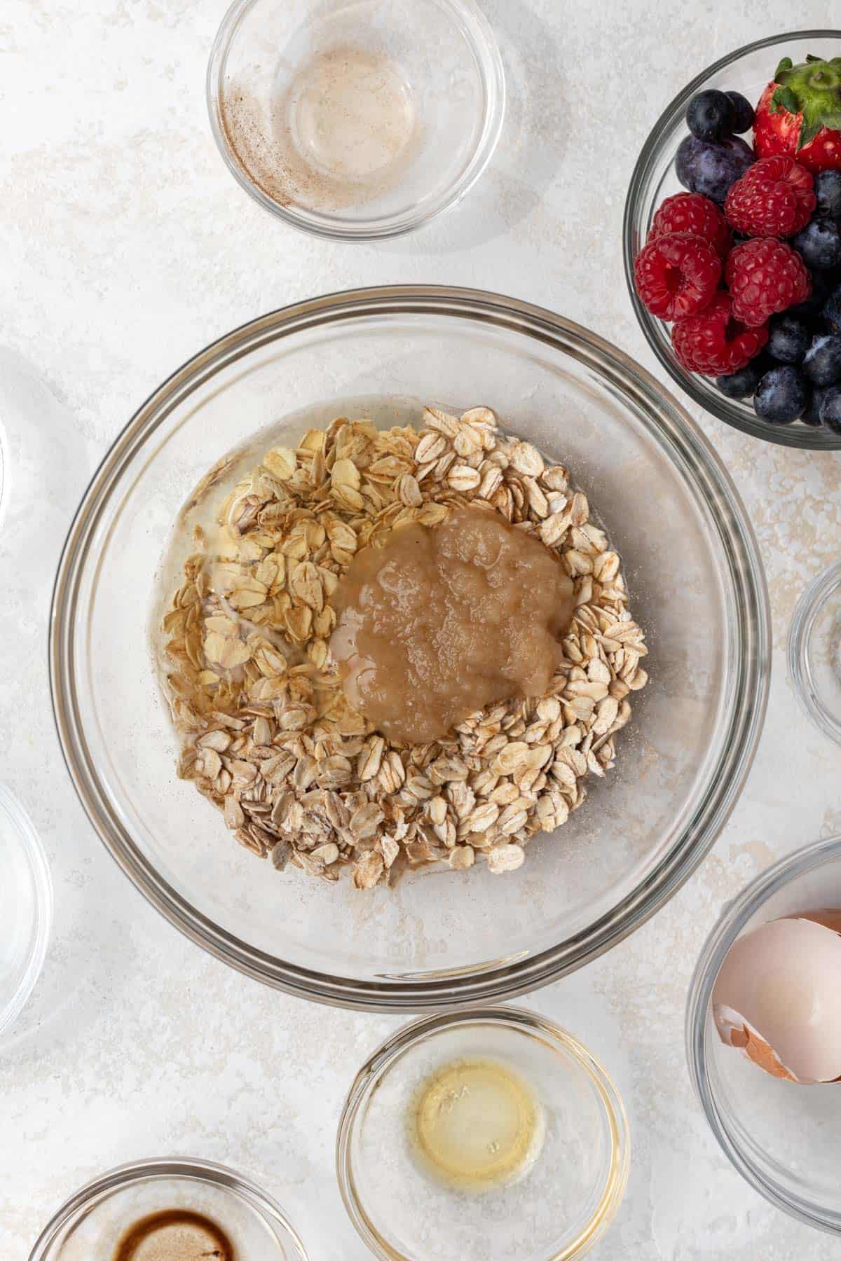 Dry and wet ingredients for baked oatmeal in a mixing bowl.