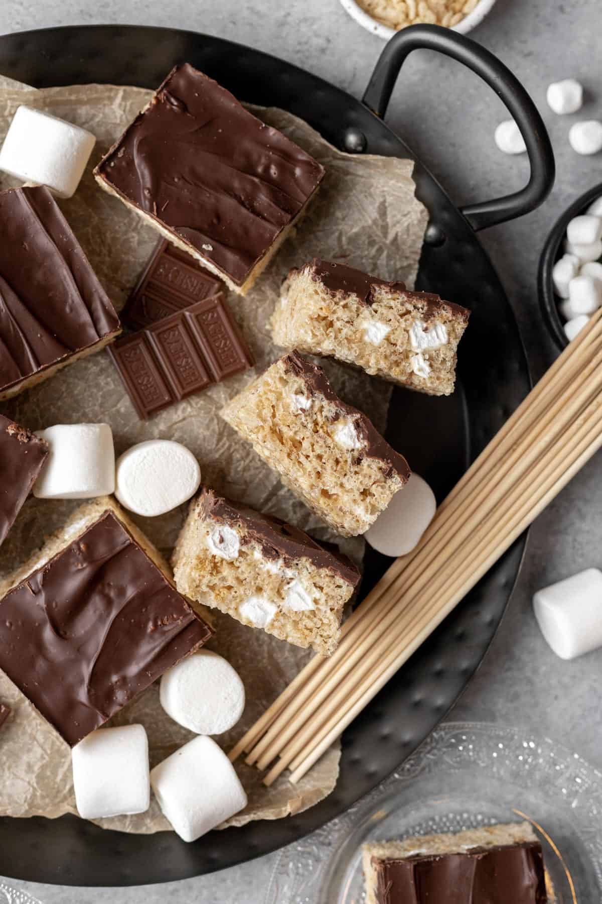 Chocolate covered smores rice krispie treats on their side to show graham crackers and marshmallows mixed in.