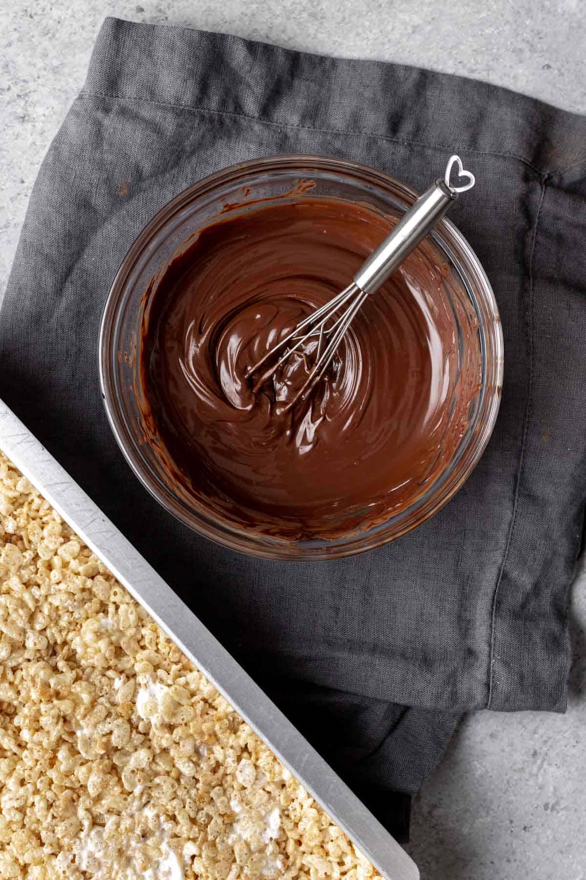 Chocolate melted with coconut oil in a glass bowl.