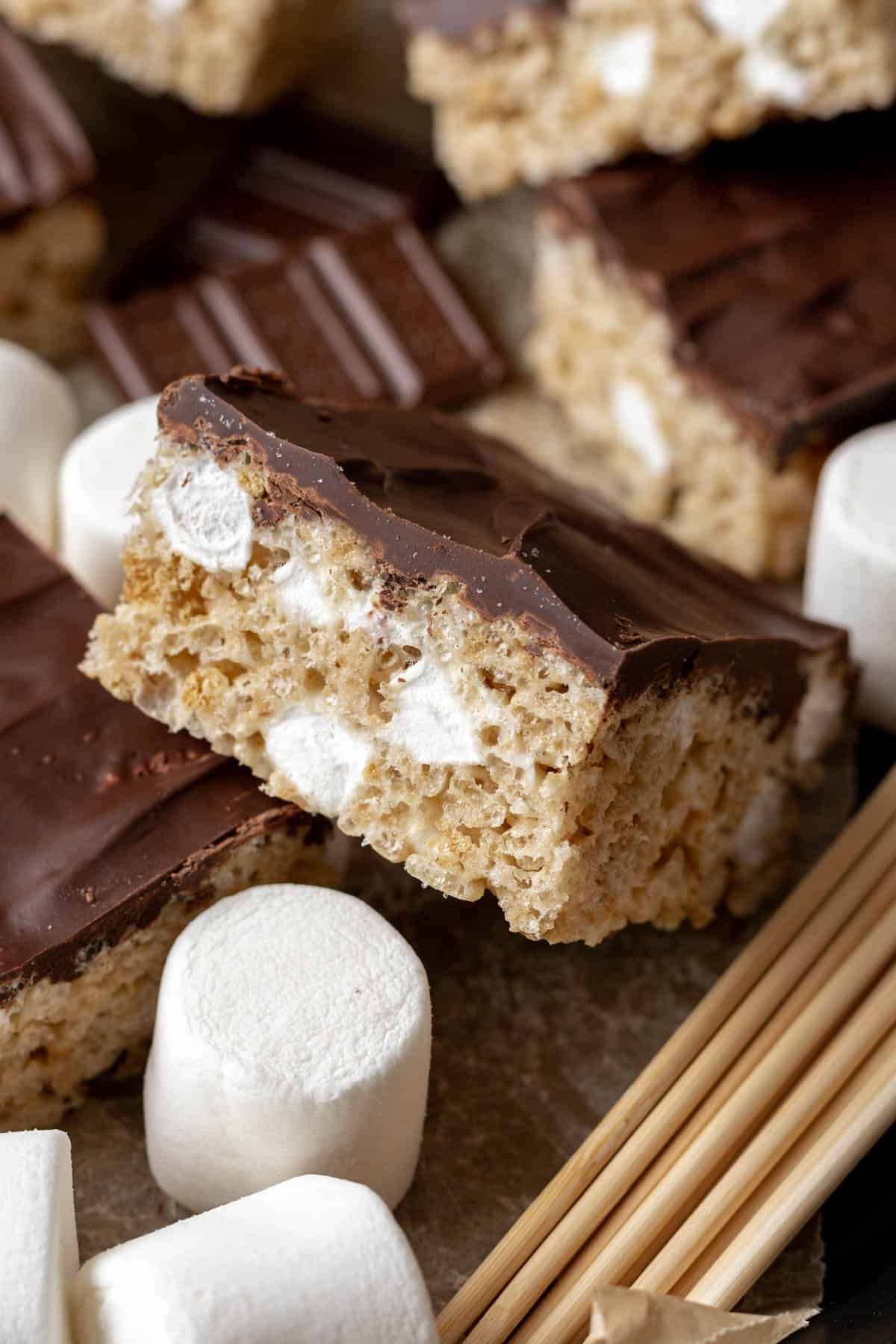 A chocolate covered smores rice krispie treat with big marshmallows around it.