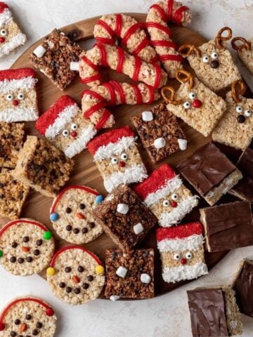 Holiday rice krispie treats arranged on a large board.