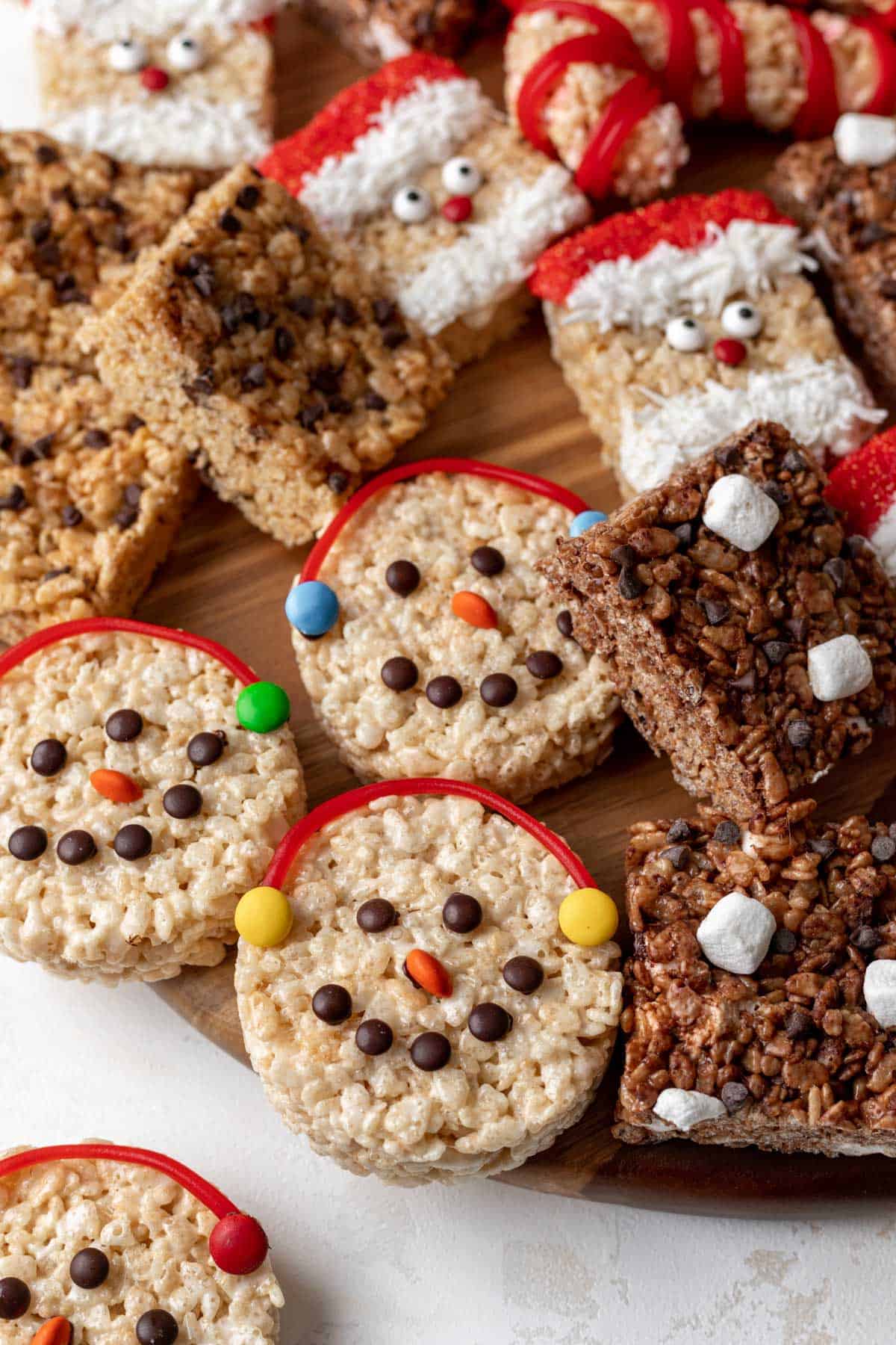 Snowman rice krispie treats on a dessert board.