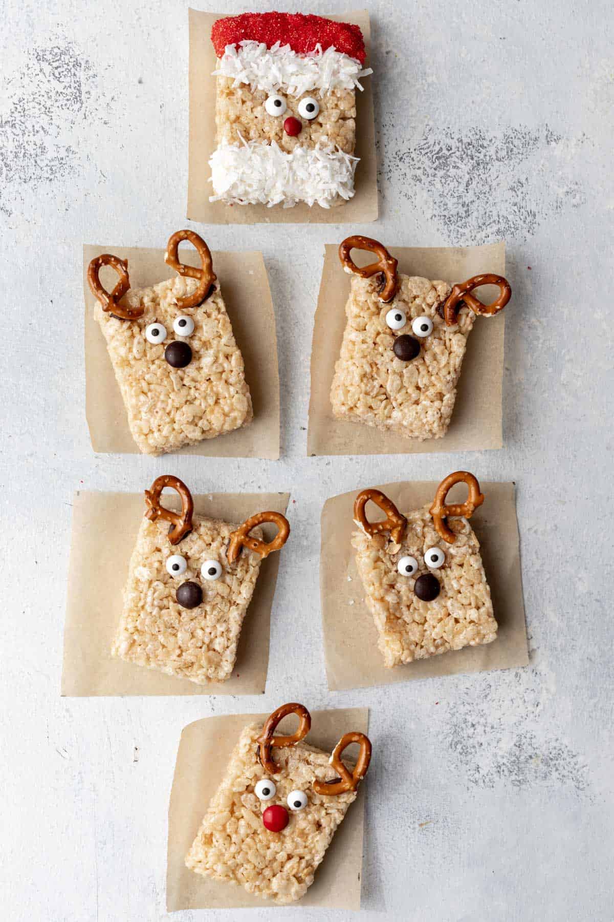 A santa rice krispie treat lined up with reindeer rice krispie treats.