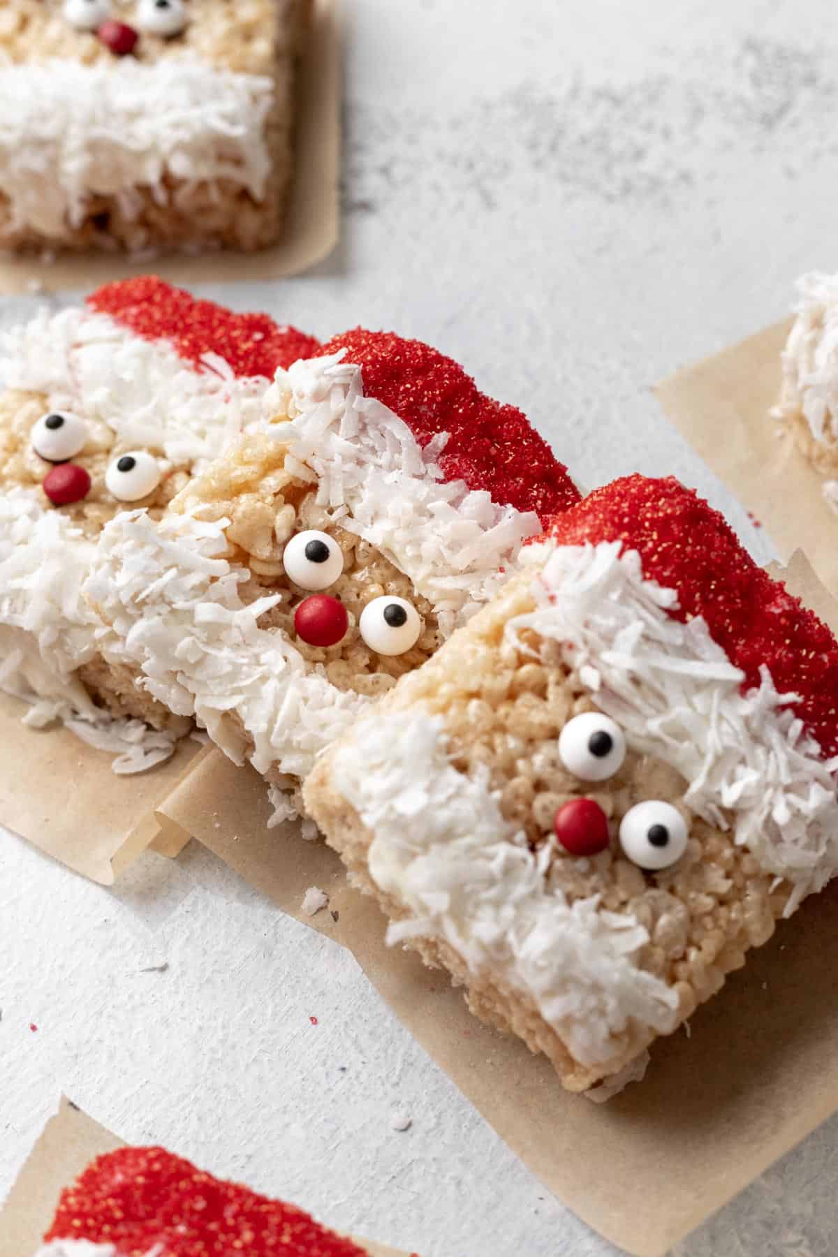 Santa rice krispie treats lined up to show their red candy noses and coconut beards.