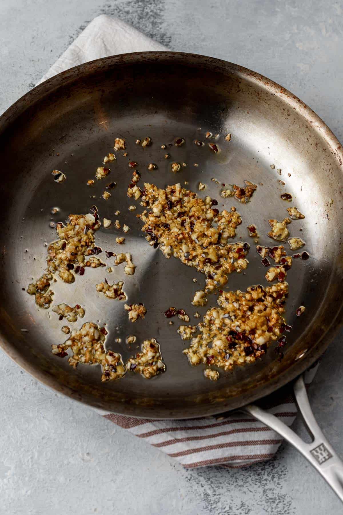 Toasted garlic, ginger, and chili flakes in a skillet.