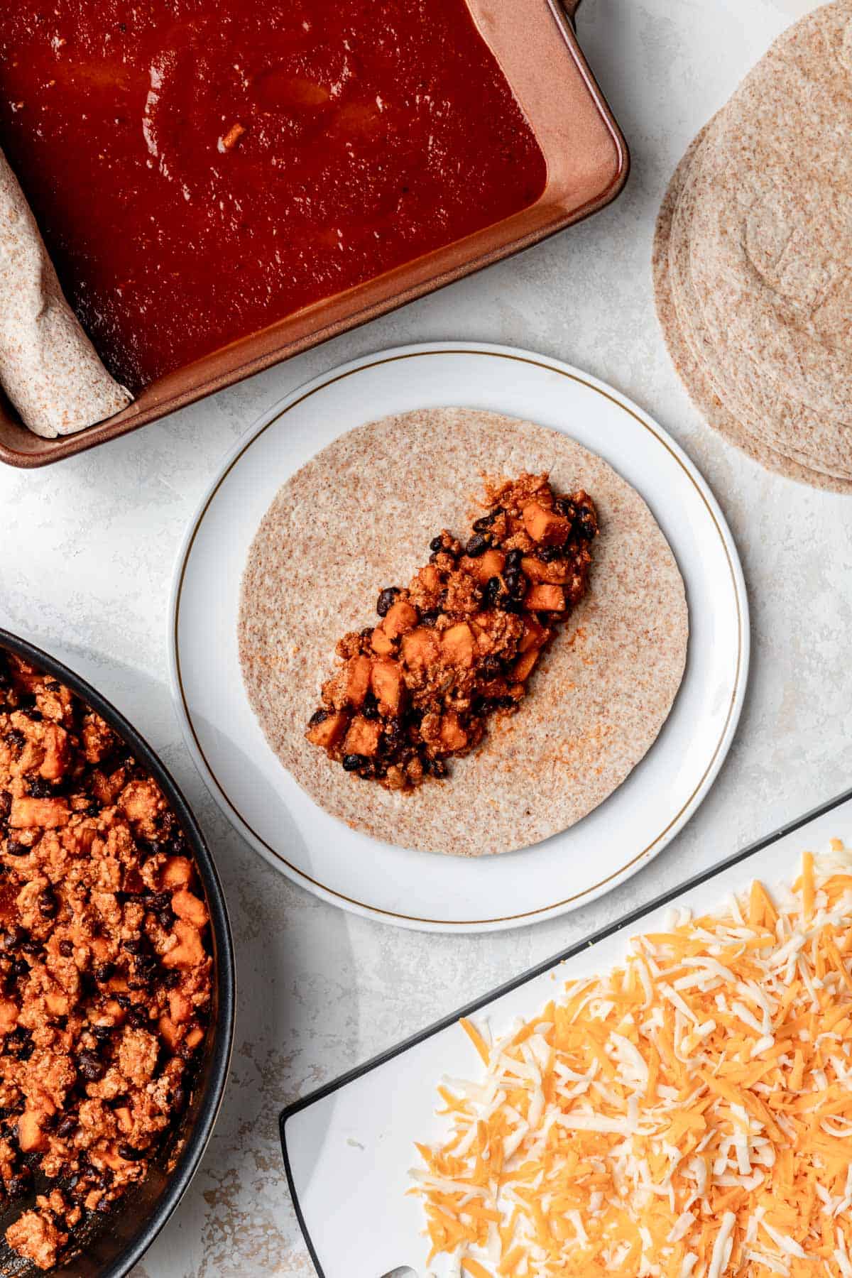 Ground turkey enchilada filling in the center of a tortilla.