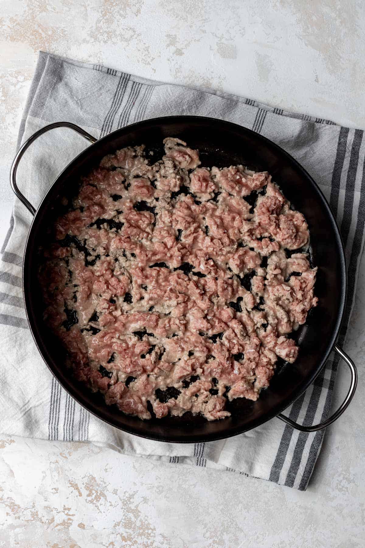 Ground turkey cooking in a large skillet.