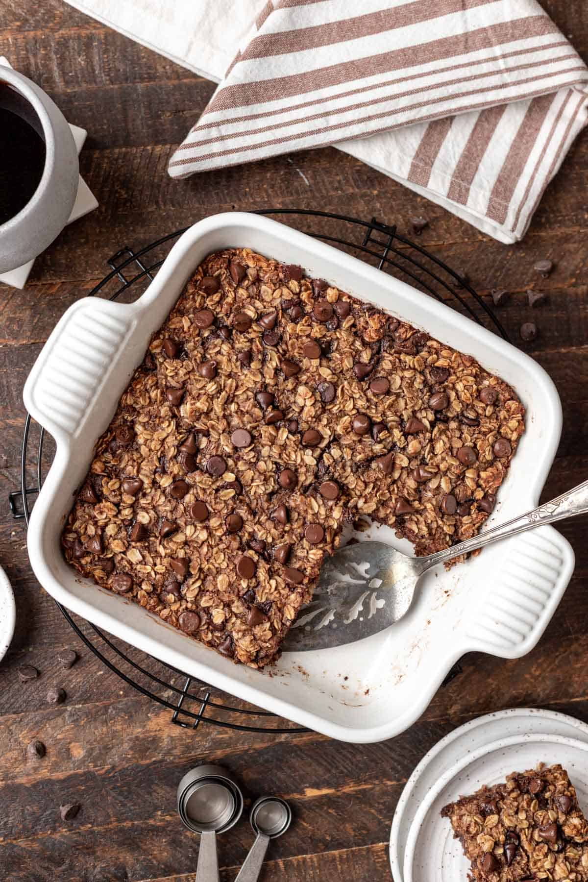 Chocolate baked oats with a slice taken out and a serving spatula.