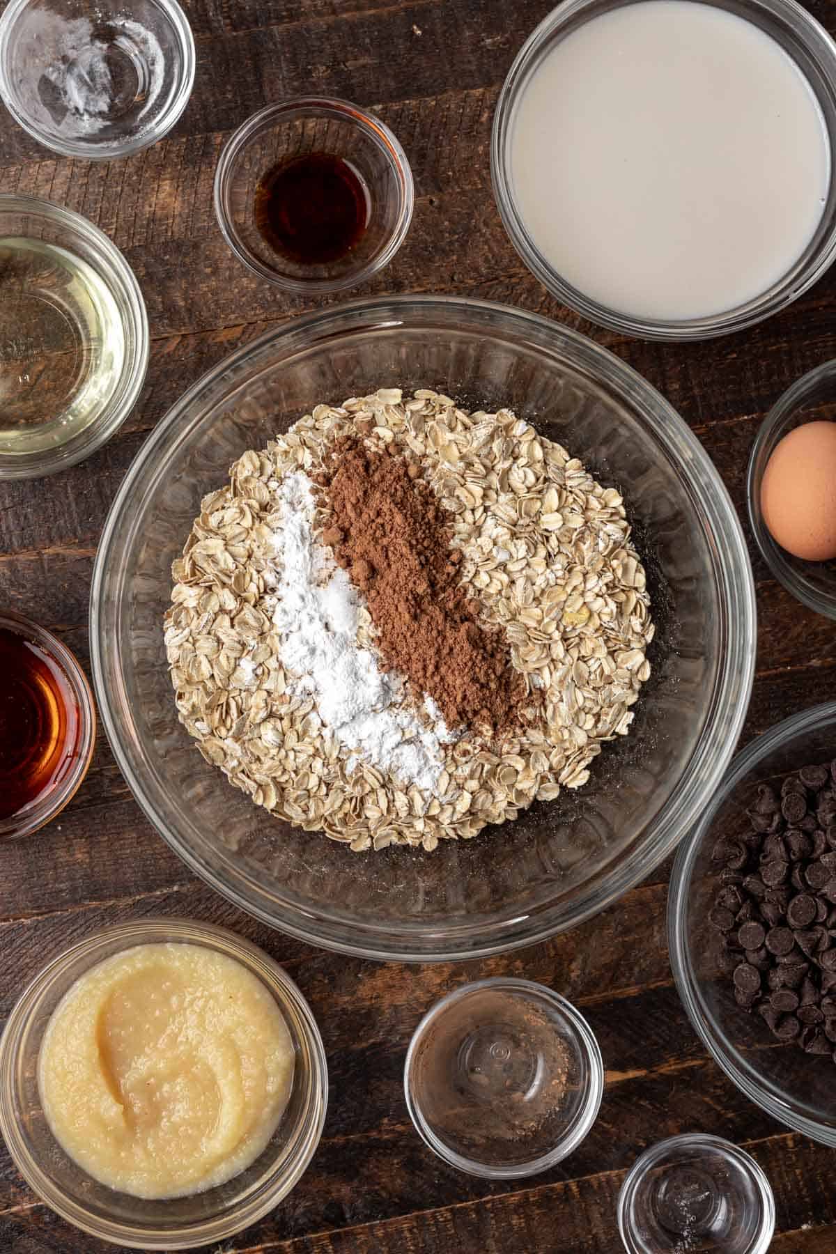 Oats in a mixing bowl with baking powder, salt, and cocoa powder.