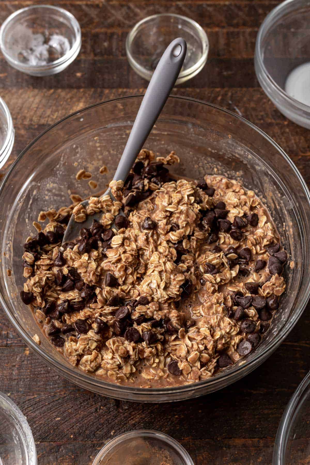 Ingredients mixed together with chocolate chips in a glass mixing bowl.