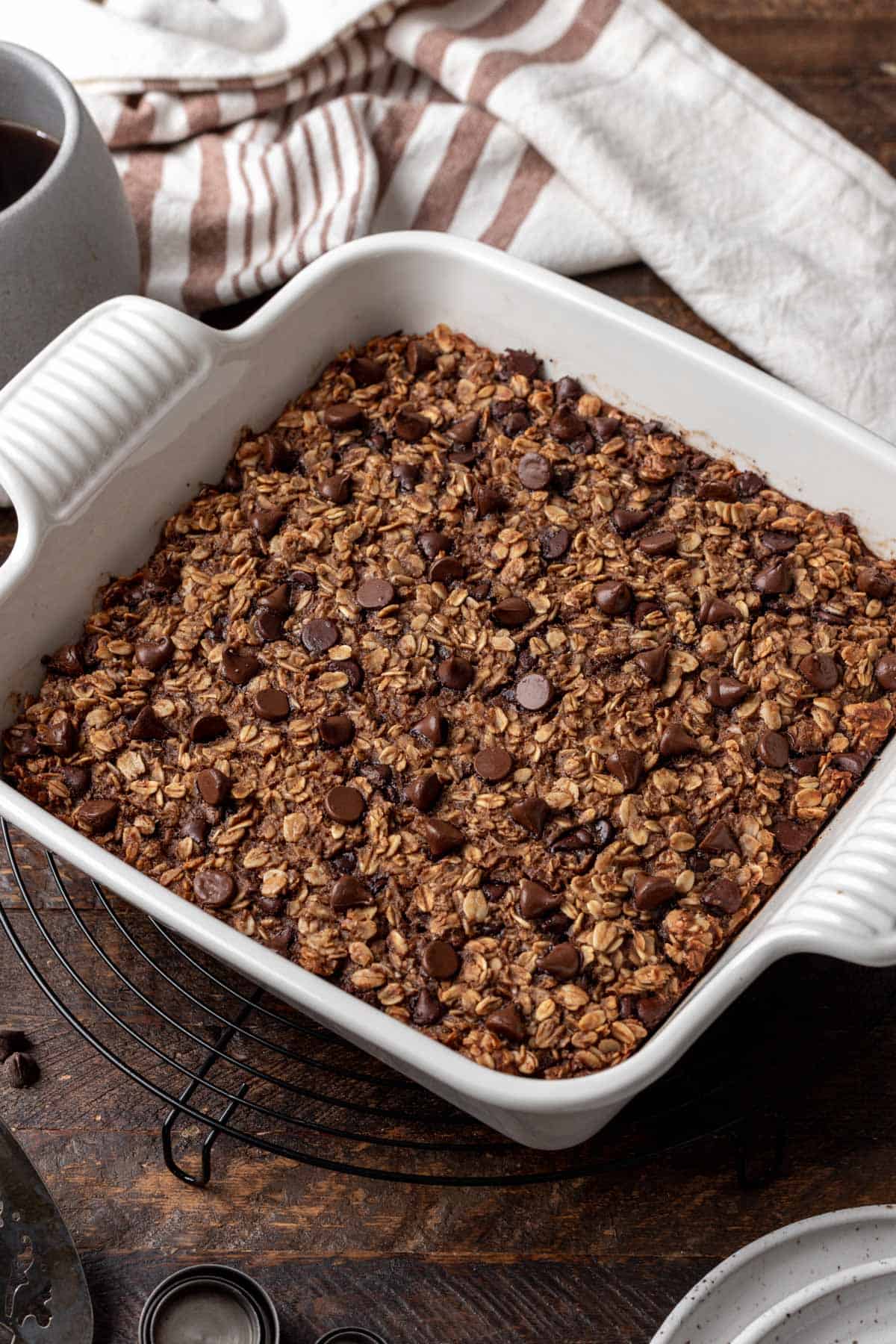 Chocolate baked oats topped with chocolate chips in a white baking dish.