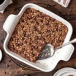Chocolate baked oats in a white ceramic baking dish with a serving spatula.