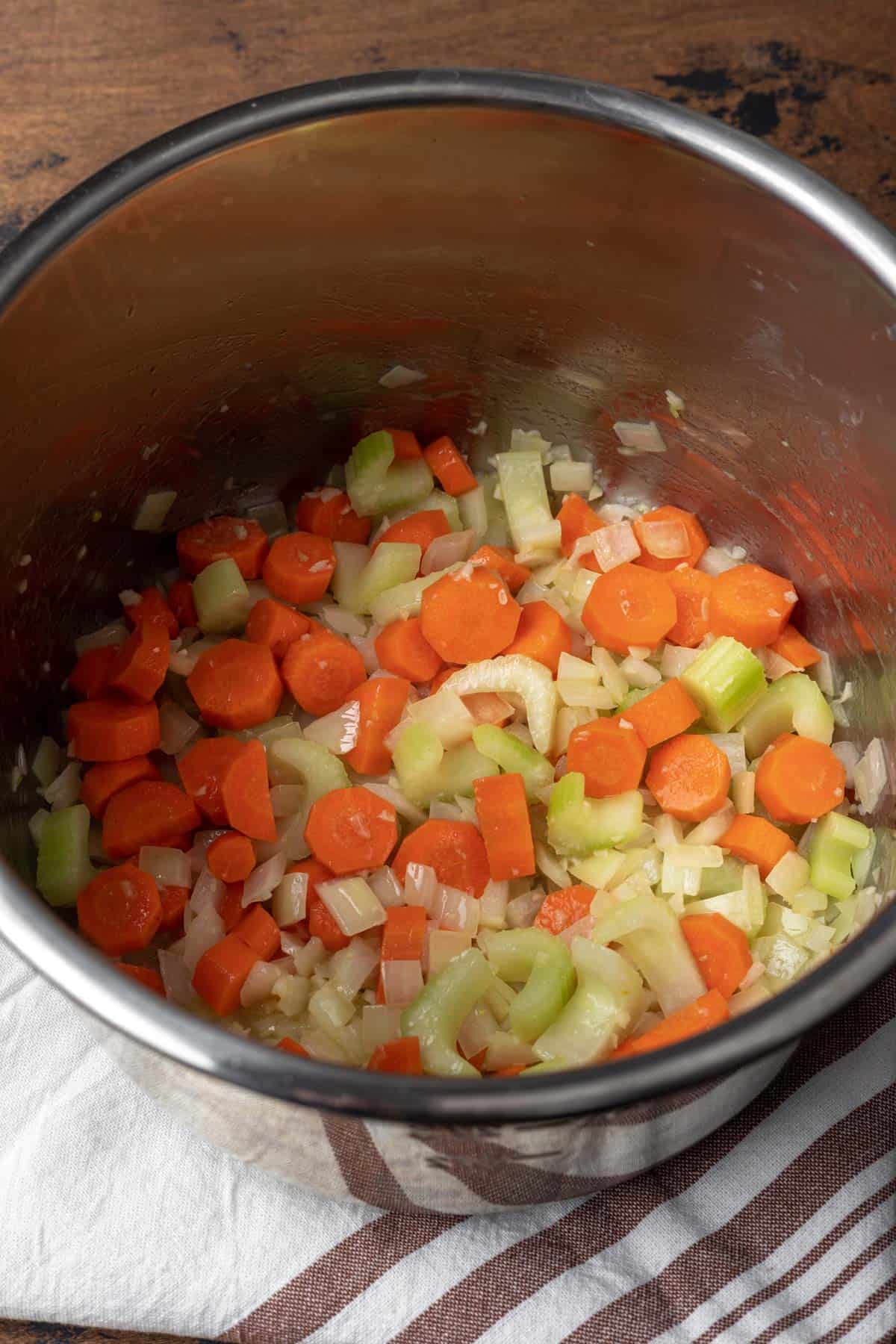 Onion, celery, carrot, and garlic sautéing in an instant pot.