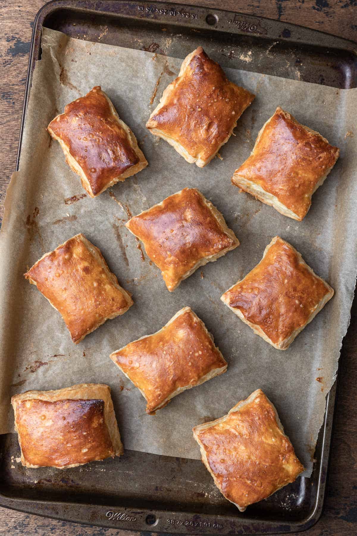 Golden brown squares of puff pastry on a sheet pan.