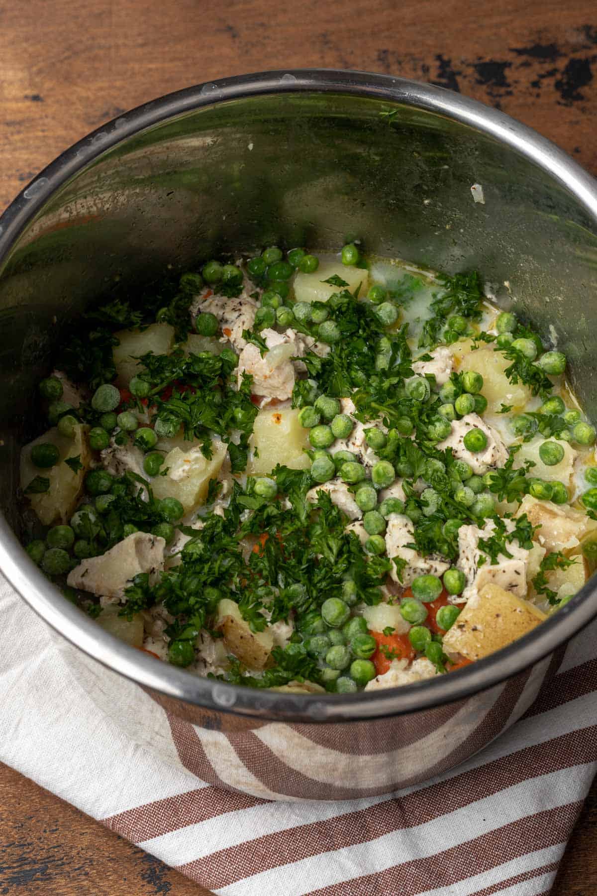 Peas and parsley added to the pot pie mixture in the instant pot.