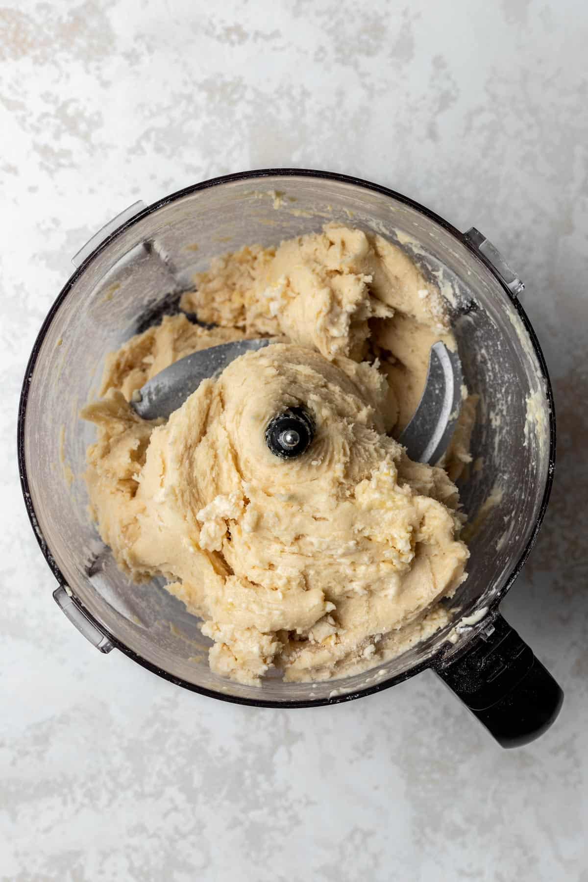 Quiche dough formed together in a food processor.