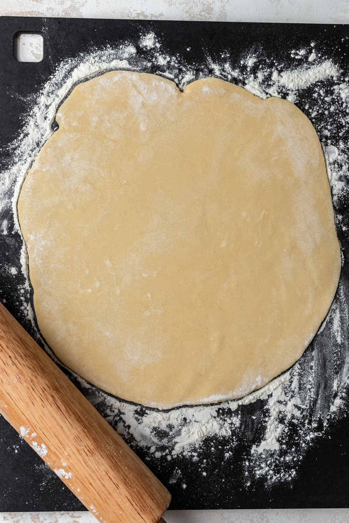 Rolled out quiche dough on a floured surface.