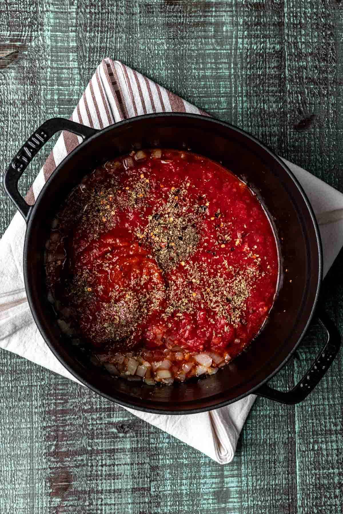 Tomato sauce seasoned with seasonings in a black pot.
