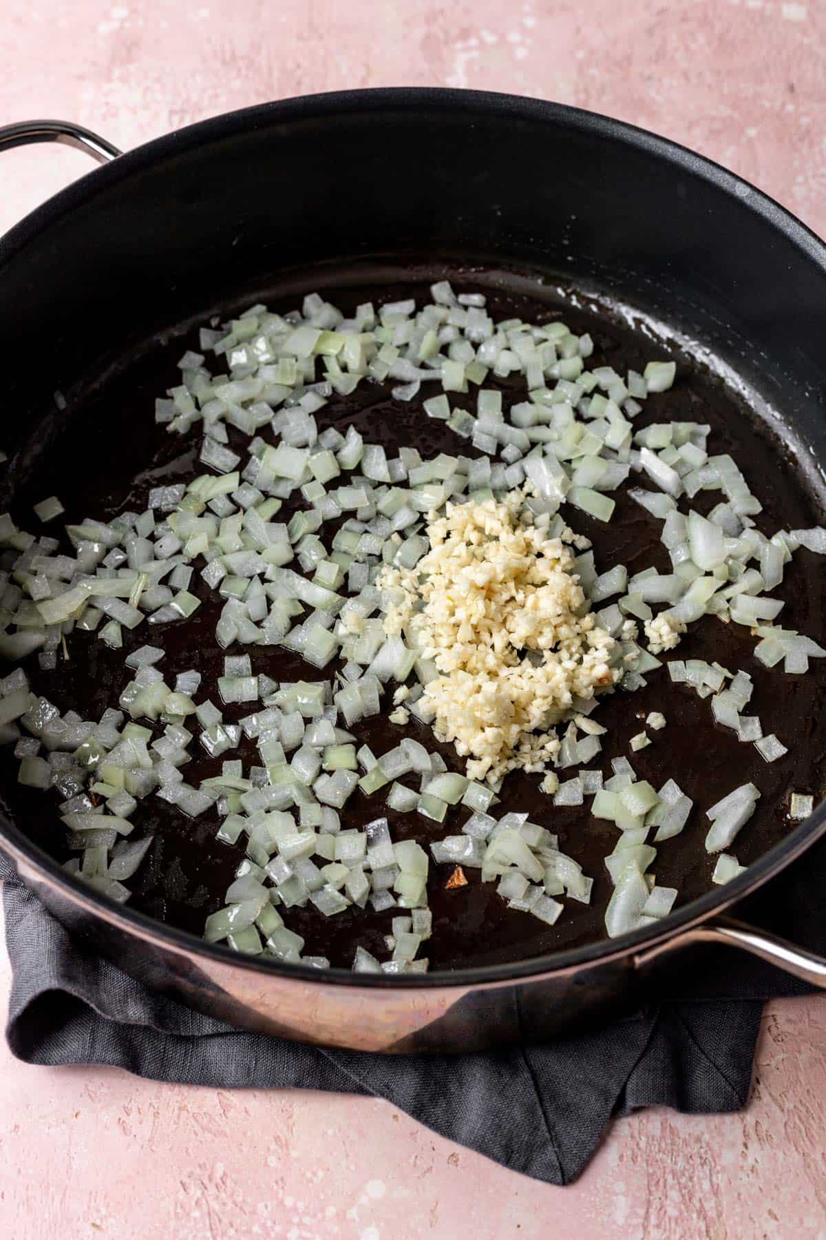 Onions and garlic sautéing in a large skillet.