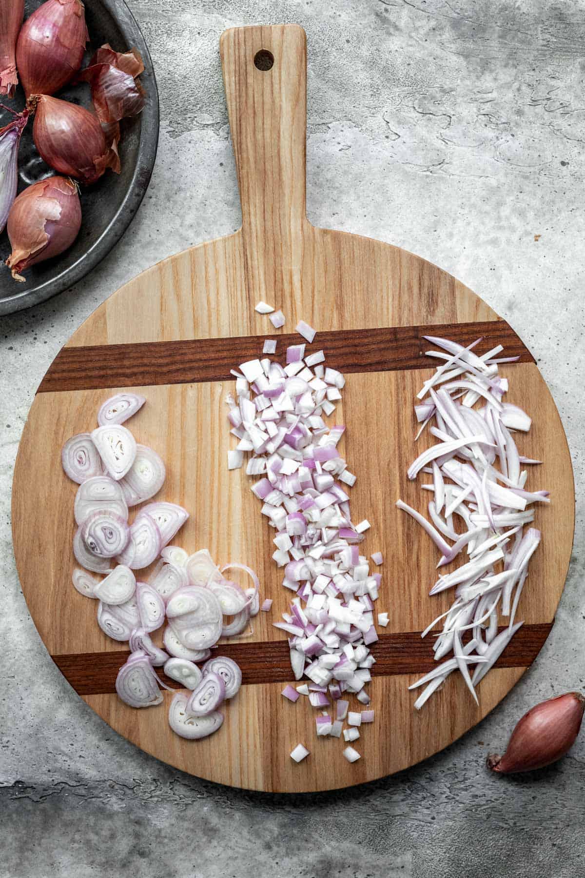 Shallots on a cutting board, cut 3 different ways.